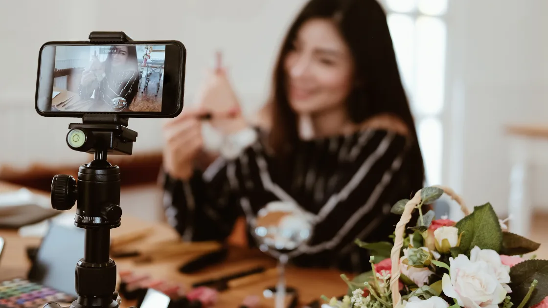 A small business owner filming social media content on a smartphone mounted on a tripod